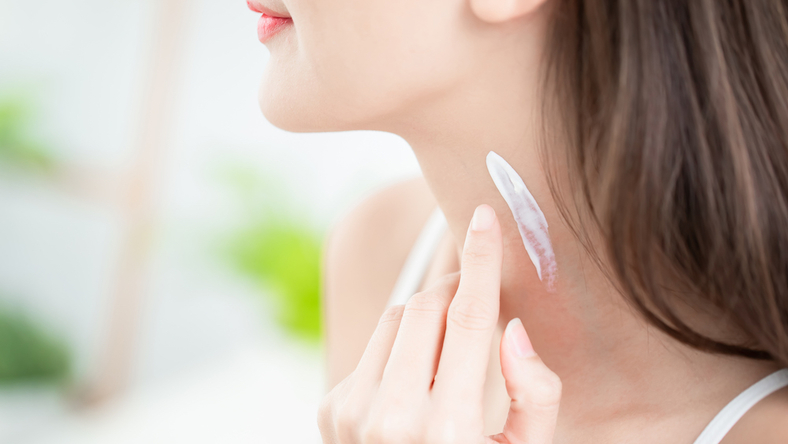 Woman applying neck cream